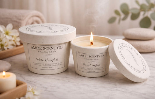Amor Scent Co candle with packaging on a table with flowers and stones in the background
